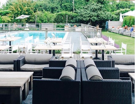 Solé East Resort poolside with outdoor dining and lush greenery in the background