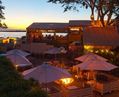Sunset Beach Hotel outdoor seating with sun umbrellas around firepit at sunset