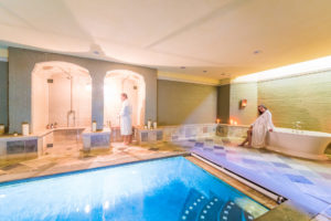 Two people relaxing at The Baker House 1650, East Hampton, Long Island Spa, featuring a pool and a bathtub