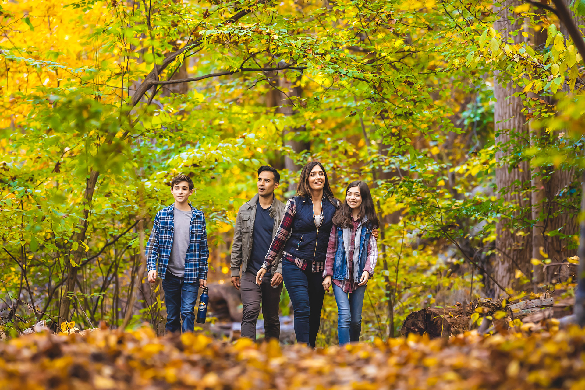 Family walking through autumn foliage on Long Island