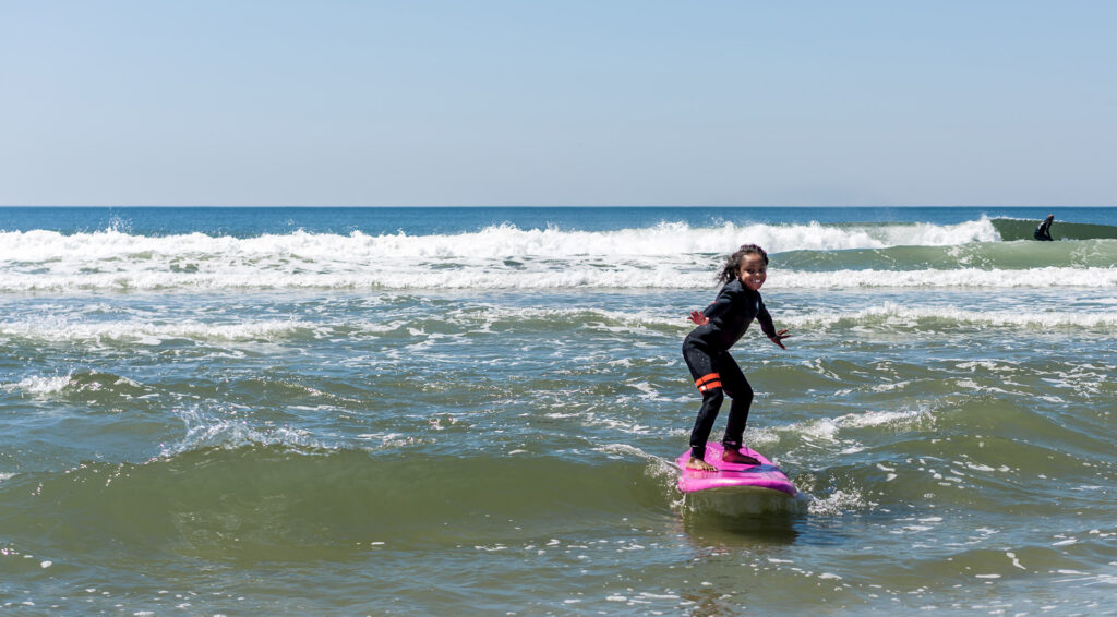Young surfer riding a wave on a Long Island beach