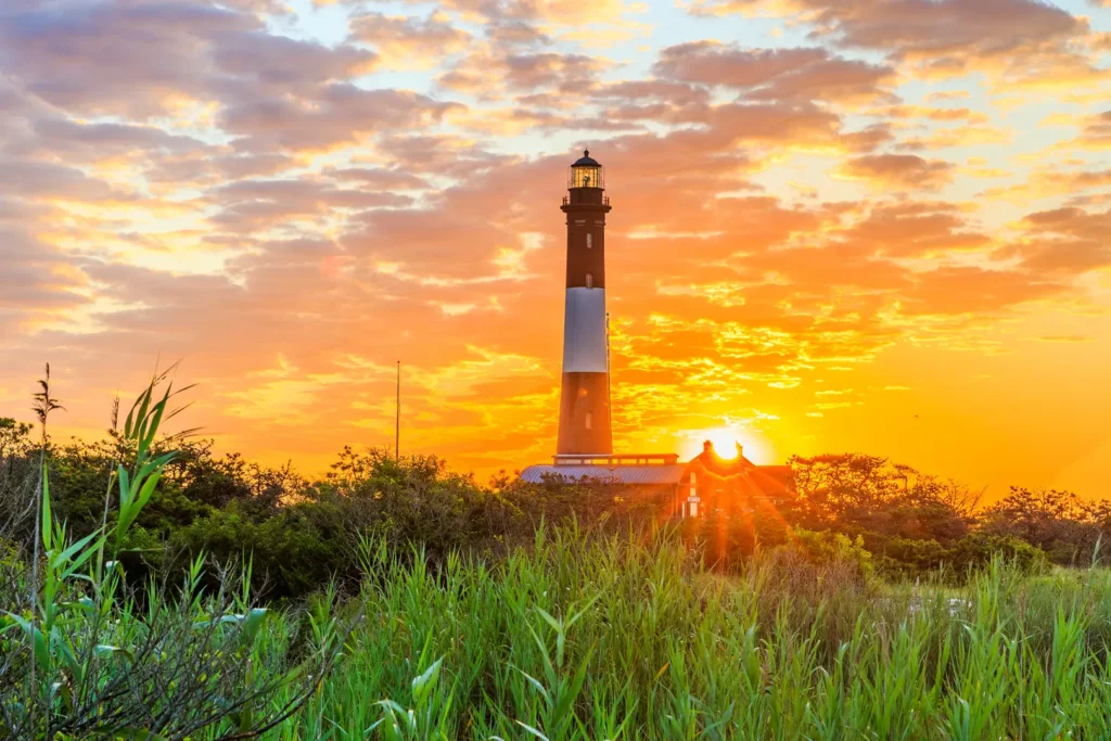 Fire Island Lighthouse silhouetted against a sunset sky on Long Island