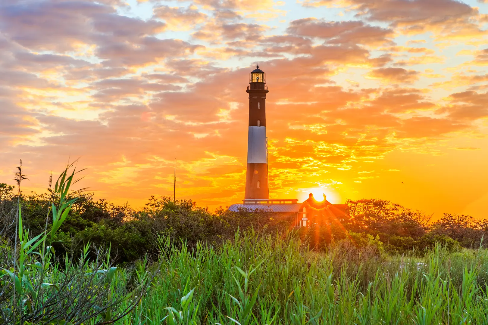 Fire Island Lighthouse silhouetted against a sunset sky on Long Island