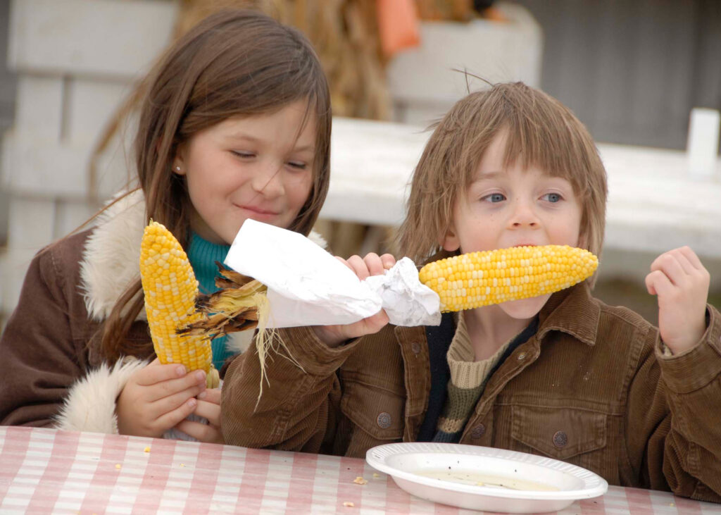 Children enjoying corn on the cob at a Long Island restaurant