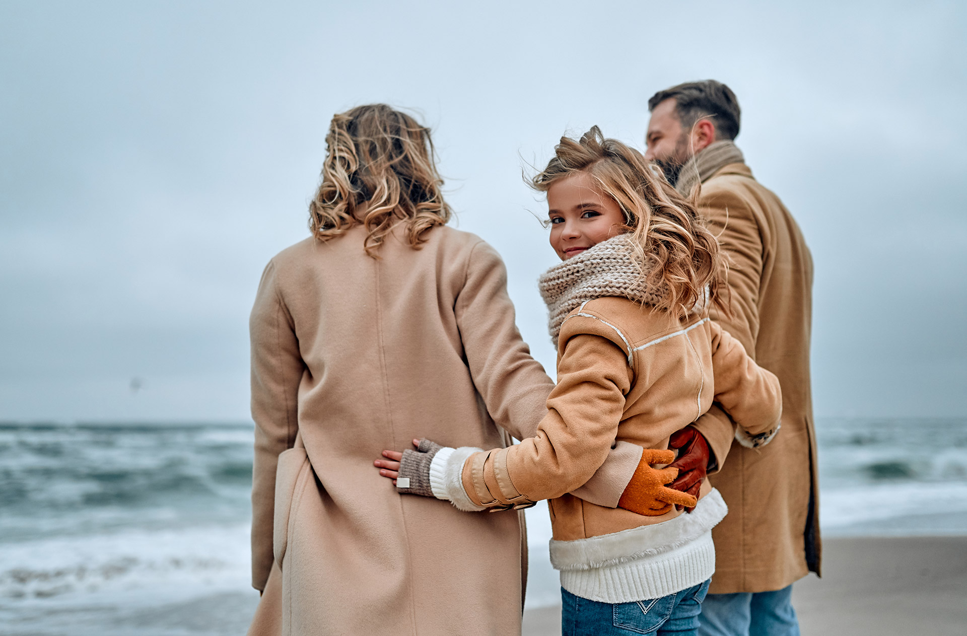 Family walking along a Long Island beach in winter