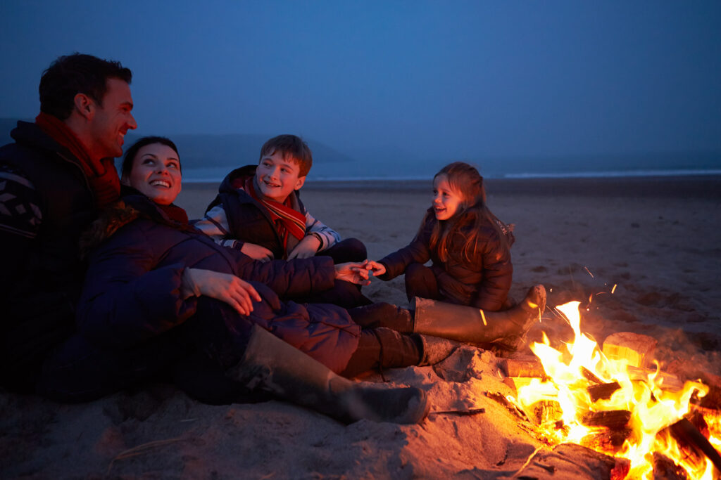 Family enjoying a bonfire on a Long Island beach
