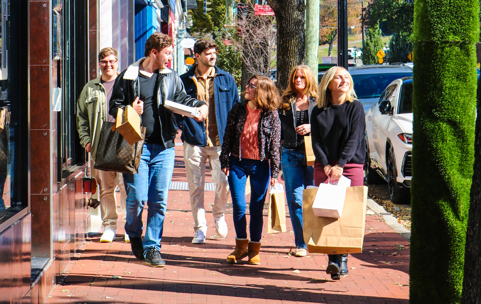 Friends walking down a shopping street in Long Island with bags