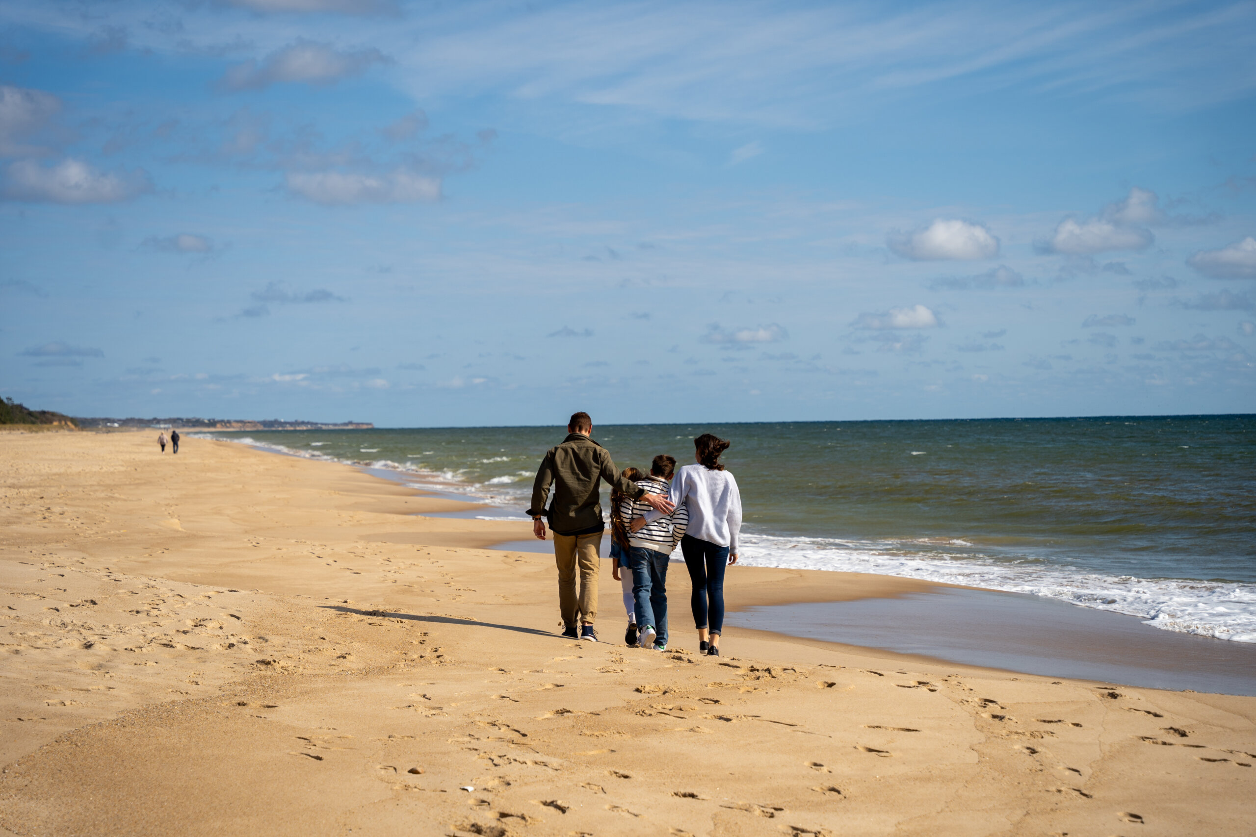 Family walking on a beach in the fall