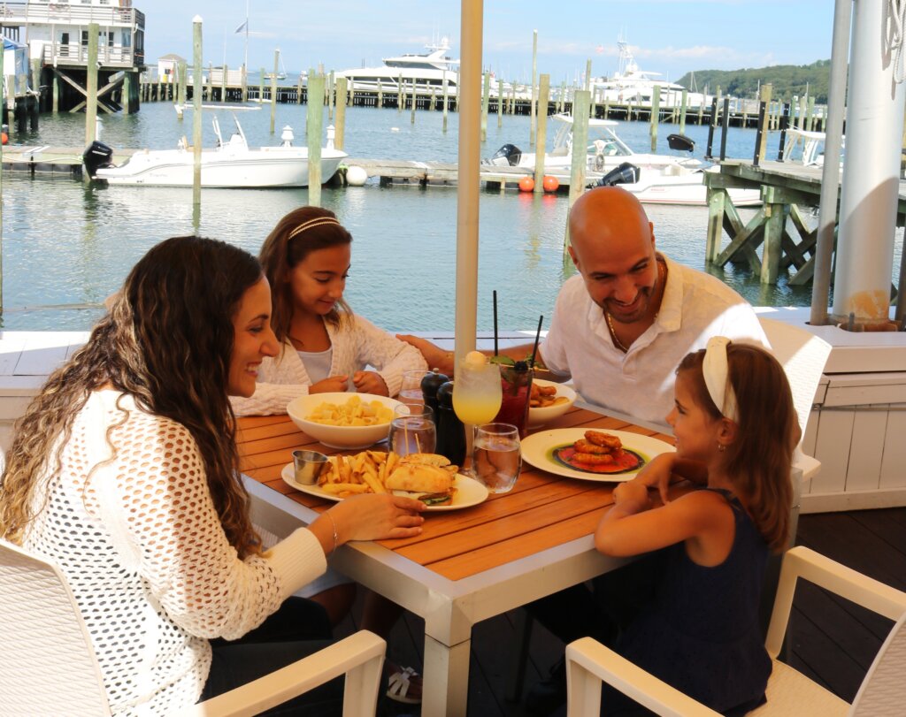 Family dining outdoors on the water